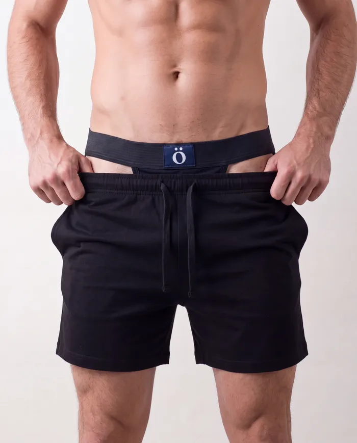 model pulling black cotton shorts up over ö-zone, waistband still visible